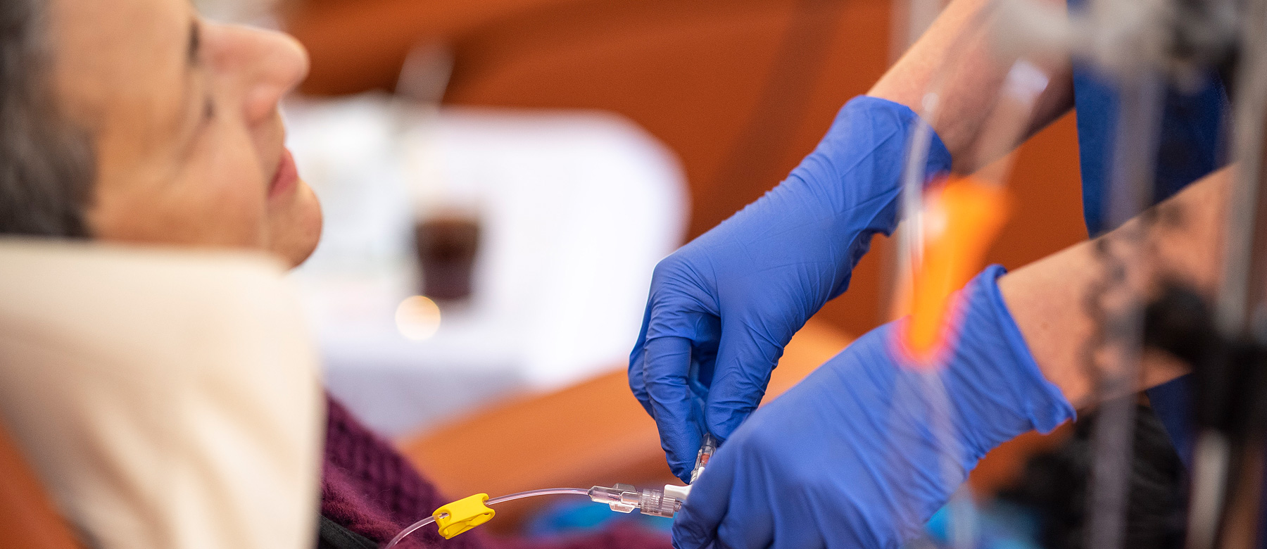 Mitarbeiterin der onkologischen Ambulanz legt einer Patienten eine Chemotherapieinfusion.