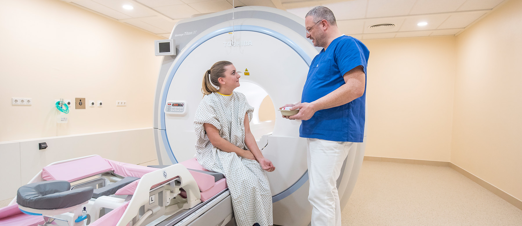 Mitarbeiter der Abteilung für Radiologie und Neuroradiologie spricht mit einer Patientin vor einer MRT-Untersuchung.