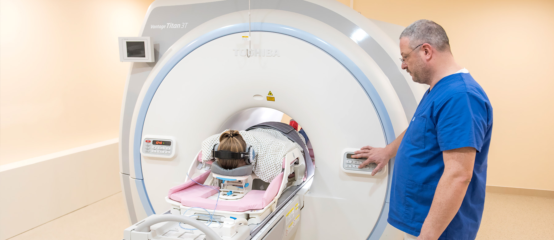 Mitarbeiter aus der Abteilung für Radiologie bedient den Magnetresonanztomographen, in dem eine Patientin untersucht werden soll.