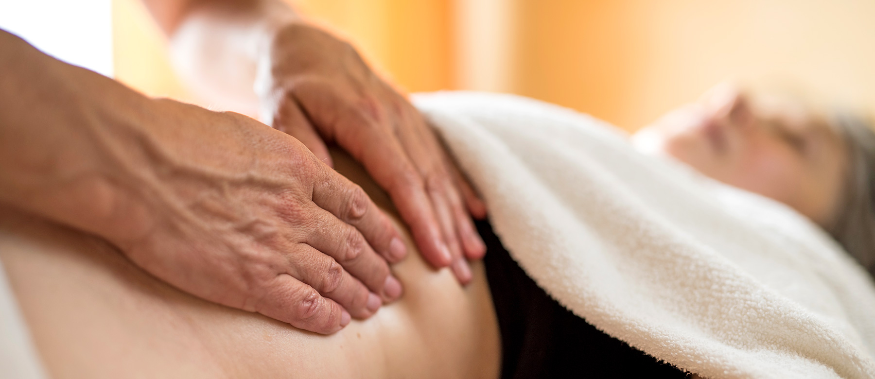 Patientin erhält ryhtmische Massage am Bauch.