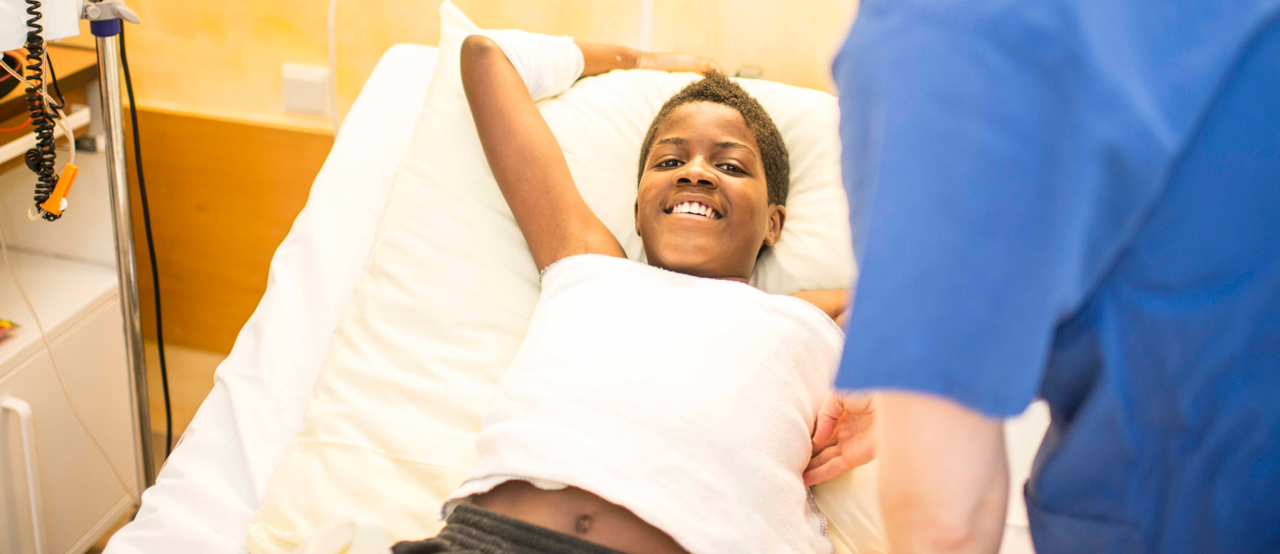 Patient der Abteilung für Kinder- und Jugendmedizin erhält einen Brustwickel und lacht dabei in die Kamera.